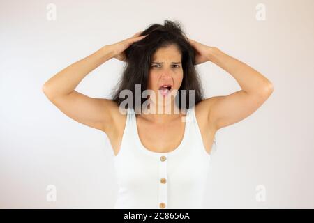 Hübsche junge Frau mit langen schwarzen Haaren macht Geste Stockfoto
