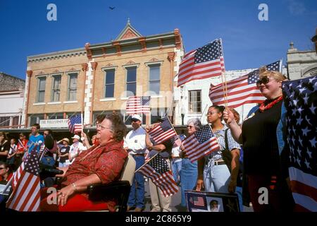 Georgetown, Texas, USA, April 2003: Die amerikanische Flagge wehende Menschenmenge nimmt an der „Support the Trupps“-Kundgebung in der Innenstadt während des Krieges im Irak Teil. ©Bob Daemmrich Stockfoto