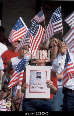 Georgetown, Texas, USA, April 2003: Die amerikanische Flagge wehende Menschenmenge nimmt an der „Support the Trupps“-Kundgebung in der Innenstadt während des Krieges im Irak Teil. ©Bob Daemmrich Stockfoto