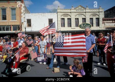 Georgetown, Texas, USA, April 2003: Die amerikanische Flagge wehende Menschenmenge nimmt an der „Support the Trupps“-Kundgebung in der Innenstadt während des Krieges im Irak Teil. ©Bob Daemmrich Stockfoto