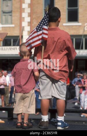 Georgetown, Texas, USA, April 2003: Die amerikanische Flagge wehende Menschenmenge nimmt an der „Support the Trupps“-Kundgebung in der Innenstadt während des Krieges im Irak Teil. ©Bob Daemmrich Stockfoto