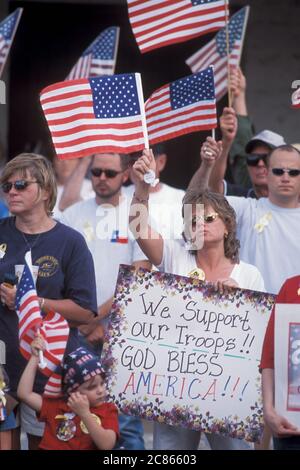 Georgetown, Texas, USA, April 2003: Die amerikanische Flagge wehende Menschenmenge nimmt an der „Support the Trupps“-Kundgebung in der Innenstadt während des Krieges im Irak Teil. ©Bob Daemmrich Stockfoto