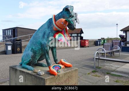 Aldeburgh, Suffolk - 21. Juli 2020: Snooks der Hund. Eine Bronzestatue, die als Denkmal für einen Hausarzt errichtet wurde. Verziert mit gestrickten Regenbögen für den NHS. Stockfoto