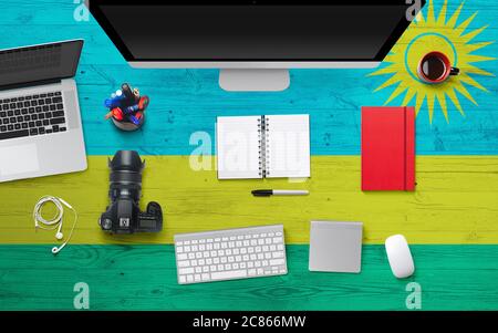 Ruanda Flagge Hintergrund mit Kopfhörer, Kamera, Notebook und Maus auf National Office Schreibtisch Table.Top Ansicht mit Copy Space.Flat Lay. Stockfoto