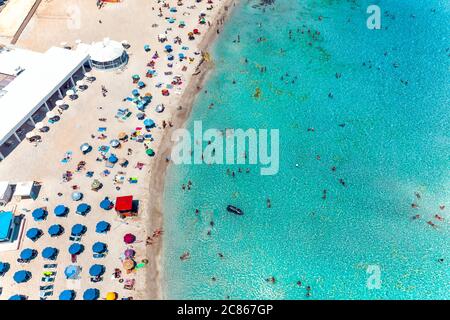 Luftaufnahme Nissi Bay Beach. Menschen, Sonnenschirme, Sand und Meereswelle. Bezirk Famagusta, zypern Stockfoto