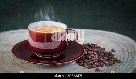 Köstlicher heißer, schaumiger Kaffee in einer braunen, glänzenden Tasse. Stockfoto