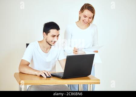 Glückliches junges Paar Rechnungen mit Laptop zusammen zu Hause berechnen Stockfoto