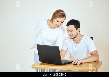 Glückliches junges Paar zu Hause, das Rechnungen mit Laptop bezahlt Stockfoto