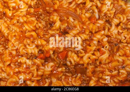 Nahaufnahme auf einer Fusilli-Pasta mit Hackfleisch und Tomatensauce mit Gewürzen und Gemüse Stockfoto