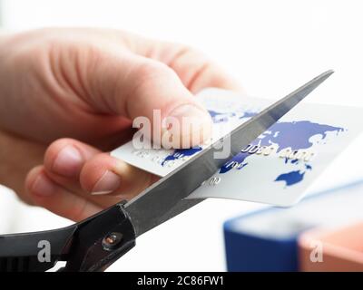 Männliche Hand schneiden Bankkarte mit Schere Stockfoto