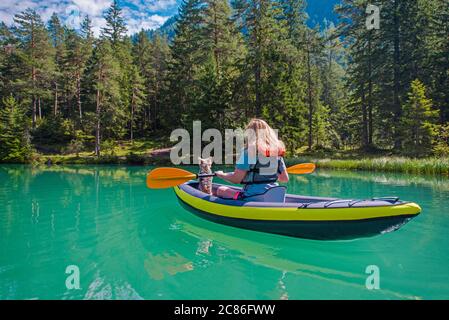 Kaukasische Frau in den 30er Jahren Kajak mit ihrem australischen Silky Terrier Hund auf Scenic Turquoise Water Austrian Lake. Thema „Kayak Recreation“ Stockfoto