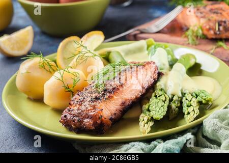 Gebackener Lachs mit Spargel und Sauce Hollandaise.Frühlingsgericht Stockfoto