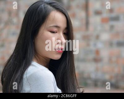 Hübsches vietnamesisches Mädchen verbeugt ihren Kopf und senkt ihre Augen. Stockfoto