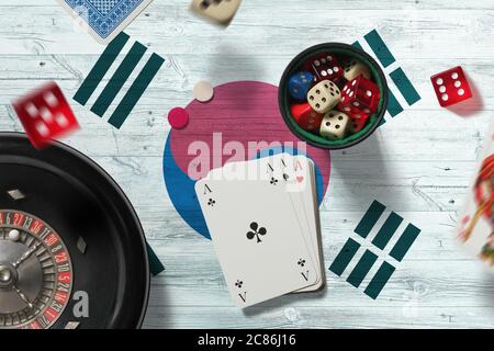 Südkorea Casino Thema. Asse im Pokerspiel, Karten und Chips auf rotem Tisch mit Nationalflagge Hintergrund. Glücksspiel und Wetten. Stockfoto