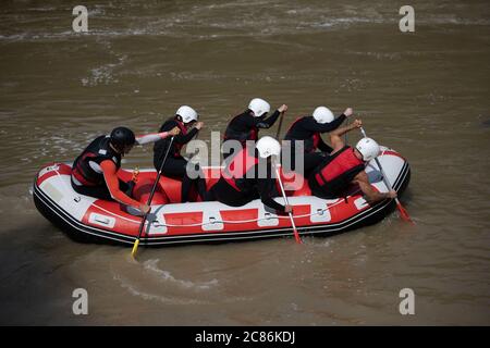 Rafting-Team-Mitglieder und Lehrer Rudern in ihrem Boot auf dem Fluss während eines herausfordernden Outdoor-Abenteuer Saison. Gruppenrekreation voller Adre Stockfoto