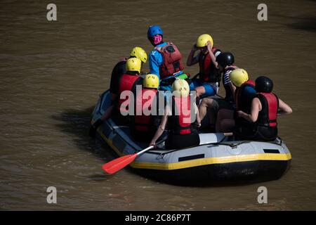 Das Rafting-Boot hielt in einem trüben Wasser an, um die Teammitglieder für ein verrücktes Abenteuer auf dem Fluss wieder zu stärken Stockfoto