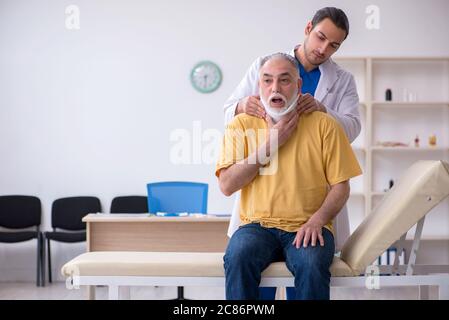 Alter Hals verletzten Mann besucht jungen Arzt Stockfoto
