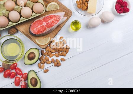 Keto Ernährung, Low Carb gesunde Ernährung. Avocado, Fisch, Öl, Nüsse auf weißem Hintergrund Stockfoto