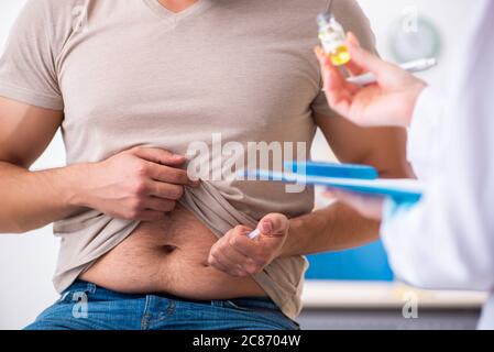 Männlicher Diabetiker, der einen jungen Arzt besucht Stockfoto