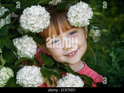 Schnupfnasen rothaarige Mädchen mit Sommersprossen ruht in der freien Luft, Spaß haben, hält weiße, faule Blumen in den Händen. Glückliche junge Dame und Frühling Stockfoto