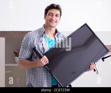 Der Mann, der versucht, defekte Fernseher zu reparieren Stockfoto
