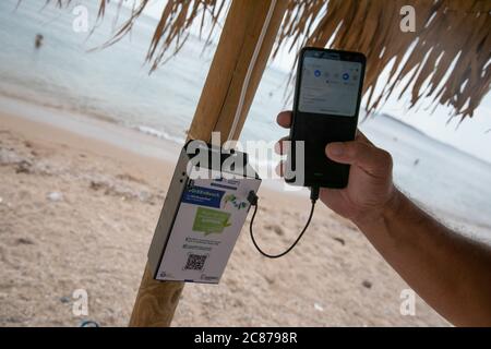 (200721) -- ATHEN, 21. Juli 2020 (Xinhua) -- das Foto vom 21. Juli 2020 zeigt ein Mobiltelefon, das über ein System von Solarmodulen und USB-Anschlüssen an einem der Sonnenschirme an einem öffentlichen Strand in der Nähe des Rathauses der Gemeinde Vari-Voula-Vouliagmeni im Süden Athens, Griechenland, aufgeladen wird. Ab Dienstag sind die Dutzende von Sonnenschirmen, die entlang des Strandes verteilt sind, gemäß den sicheren Entfernungsmaßnahmen zum Schutz gegen COVID-19, mit einem System aus Solarmodulen und USB-Anschlüssen ausgestattet, das kostenlos und umweltfreundlich aufgeladen werden kann. Unter einem Pilotprogramm am Dienstag gestartet, sunba Stockfoto