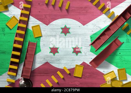 Burundi Flagge mit nationalem Hintergrund mit Dominosteine auf Holztisch. Draufsicht. Spielkonzept. Stockfoto