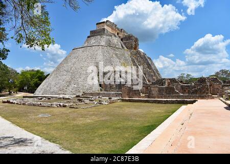Die Pyramide des Magiers mit umliegenden Ruinen und Pfaden in der antiken Maya-Stadt Uxmal auf der Halbinsel Yucatan, Mexiko. Stockfoto