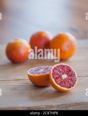 Innenaufnahme eines Studios von einer Gruppe von Blutorangen auf einer natürlichen Oberfläche. Sanguine Orangen. Rot-orange. Nahaufnahme. Selektiver Fokus. Stockfoto