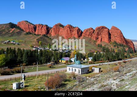 Djety-Oguz Tal und Schlucht in Issyk-Kul Region in Kirgisistan. Kleine Moschee mit rotem Sandstein Felsen bekannt als die Seven Bulls Rock dahinter. Jeti Oguz. Stockfoto