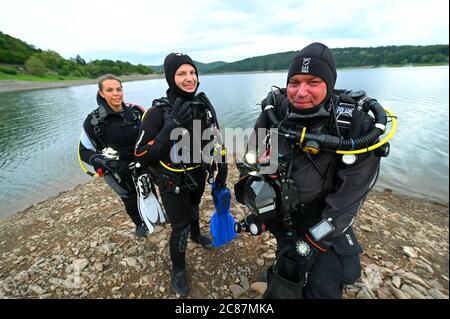 Waldeck, Deutschland. Juli 2020. Die Tauchschüler Constantin Mühr (l-r) und Justina Fuchs stehen mit Tauchlehrer Stefan Pape vor dem Nachttauchgang am Ufer des Edersee. Tief, grün und dunkel - das Tauchen im nordhessischen Stausee ist schon tagsüber ein Abenteuer. Aber wenn Sie den See von einer neuen Seite kennenlernen möchten, können Sie nachts hinein klettern. (Zur Sommerserie 'Night Shift' - 'im Dunkeln in die Tiefe - Nachttauchen am Edersee') Quelle: Uwe Zucchi/dpa/Alamy Live News Stockfoto