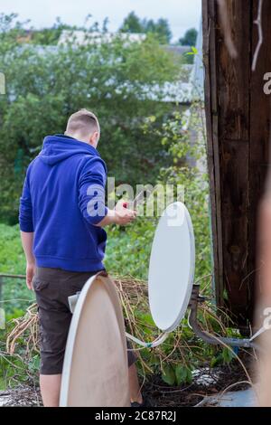 Beschneidung von Pflanzen auf dem Dach eines Dorfhauses. Stockfoto