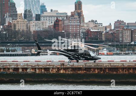 'Uber Copter' - ein schwarzer Bell 430 Hubschrauber mit Uber-Marke am New Yorker Downtown Manhattan Heliport, der Passagiere zum Flughafen bringt Stockfoto