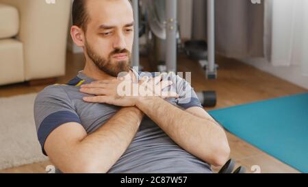 Mann in Sportbekleidung Training abs auf schweizer Ball im Wohnzimmer. Stockfoto