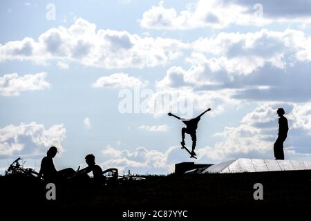 Berlin, Berlin, Deutschland. Juli 2020. Auf einem Skatepark im Tempelhofer Feld am ehemaligen Flughafen Tempelhof sind Silhouetten von Athleten gegen den Abendhimmel zu sehen. Aufgrund der weltweiten Covid-19-Pandemie sind die Sporteinsätze an allen öffentlichen und privaten Sportanlagen, Schwimmbädern und Fitnessstudios in Berlin noch eingeschränkt. Auf Outdoor-Sportanlagen ist die Ausübung kontaktloser Sportarten jedoch erlaubt. Quelle: Jan Scheunert/ZUMA Wire/Alamy Live News Stockfoto