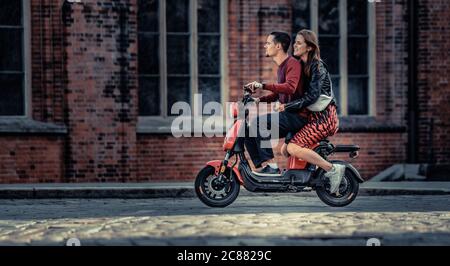 20-07-2020 Riga, Lettland schönes junges Paar, das im Sommer mit dem Elektrofahrrad unterwegs ist. Moderne Stadt Datierung und Transport. Stockfoto