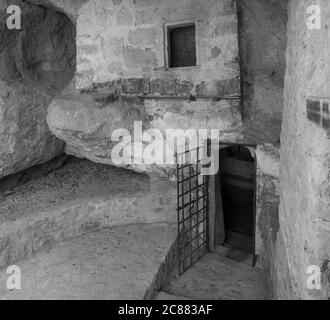 Eingang offen Dor zu Dungeon thomb oder Gefängniszelle mit verrosteten Eisengitter auf mittelalterlichen Burg, schwarz und weiß, Kopierraum Stockfoto