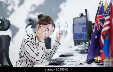 Müde Casual Business Frau, die eine Pause während der Arbeit auf Desktop-Computer in modernen offenen Plan Startup-Büro Innendeadline Stress-Konzept Stockfoto