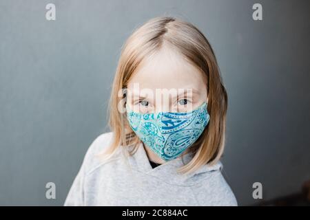 Mädchen Kind trägt Stoffmasken während der Corona COVID-19 Pandemie, sind Masken jetzt obligatorisch. Stockfoto