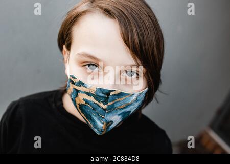 Knabe Kind trägt Stoffmasken während der Corona COVID-19 Pandemie, sind Masken jetzt obligatorisch. Stockfoto