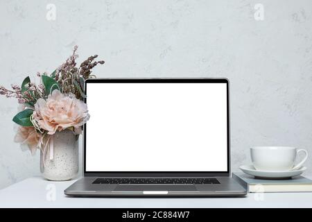 Laptop mit leerem Bildschirm auf weißem Schreibtisch. Arbeitsplatz zu Hause. Stockfoto