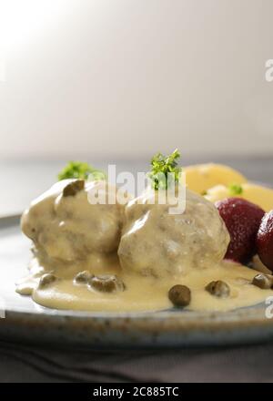 Königsberger Klopse oder gekochte Fleischbällchen in weißer Sauce mit Kapern, Rote Beete Kartoffeln und Petersilie garnieren, traditionell in Deutschland und Polen, Kopie sp Stockfoto