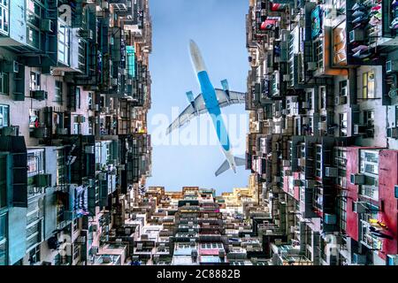 Das Flugzeug fliegt über das Berghaus in der Nähe von Tai Koo in Hongkong. Überfülltes altes Retro-Gebäude Stockfoto