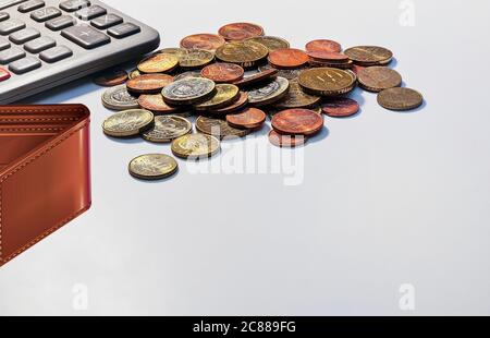 Euro-Münzen. Isoliert. Europäische lose Münzen mit Taschenrechner und Geldbörse auf weißem Hintergrund. Platz zum Schreiben. Bild Auf Lager. Stockfoto