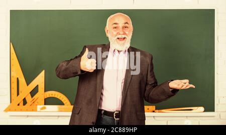 Spüren Sie den Erfolg. Trigonometrie-Lektion im Klassenzimmer. Lernen Sie hier. Lehrer für leitende Männer verwenden mathematische Werkzeuge. Bärtiger Dozent erklärt Geometrie auf der Tafel. Zurück zur Schule. Mathematische Grafikwerkzeuge. Stockfoto