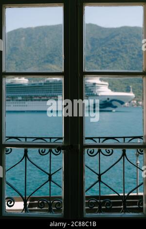 Der Kreuzfahrtschiff fährt im Fenster des Hotelzimmers. Stockfoto