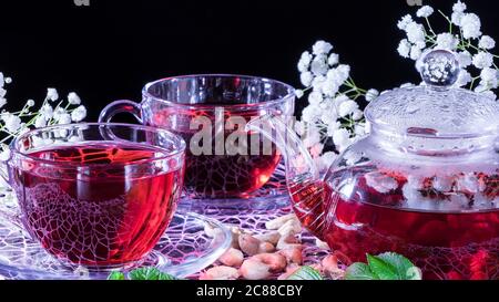 Hibiscus Rote Tee Tasse mit Nelke Blumen close-up horizontale Foto.Englische Tee-Tradition.Medizinische Therapie auf der Grundlage von Heilkräutern und Abkokationen. Stockfoto