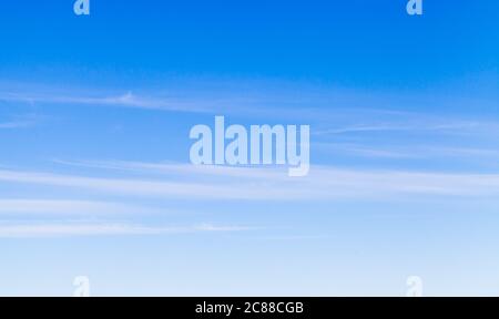 Blauer Himmel mit windigen Zirruswolken am Tag, natürliche Hintergrund Foto Textur Stockfoto