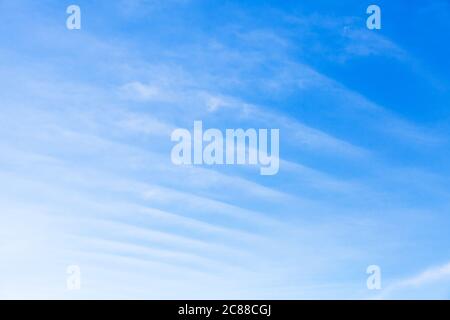 Streifen von windigen Wolken am blauen Himmel bei Tag, natürliche Foto Hintergrund Textur Stockfoto