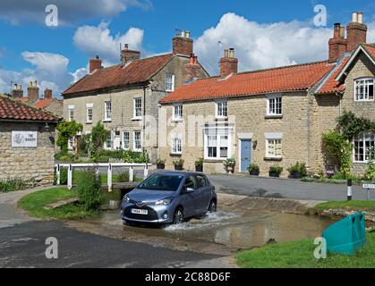 Toyota Yaris Auto Kreuzung ford im Dorf Hovingham, Ryedale, North Yorkshire, England Großbritannien Stockfoto